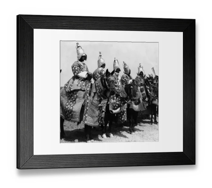 Framed Print : Nigerian tribesmen attired in traditional dress parade before the Queen during here tour