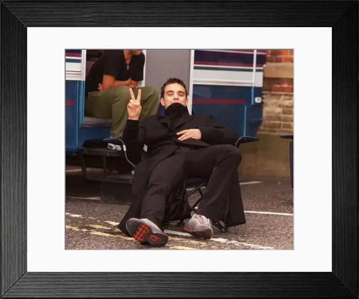 Framed Print : Robbie Williams relaxes on the set of his lastest video being shot in the grounds of Framed Print : Robbie Williams relaxes on the set of his lastest video being shot in the grounds of