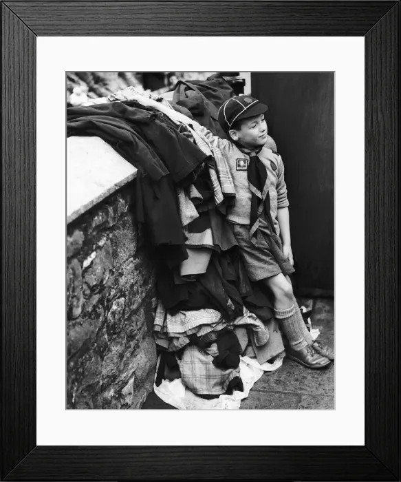Framed Print : Scouts Peter Roberts aged 8 guards a pile of coats as his pack take part in a carnival Framed Print : Scouts Peter Roberts aged 8 guards a pile of coats as his pack take part in a carnival