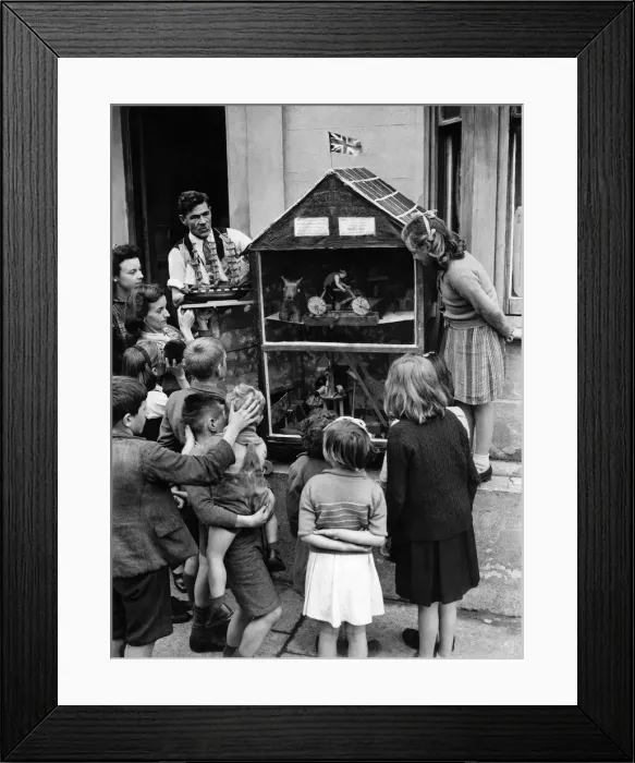 Framed Print : Tom Binnie in apron and his wife placing toy ship model in showcase before one of Framed Print : Tom Binnie in apron and his wife placing toy ship model in showcase before one of