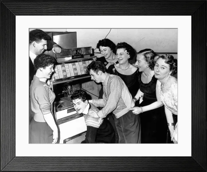 Framed Print : Teenagers crowd round a juke box Framed Print : Teenagers crowd round a juke box