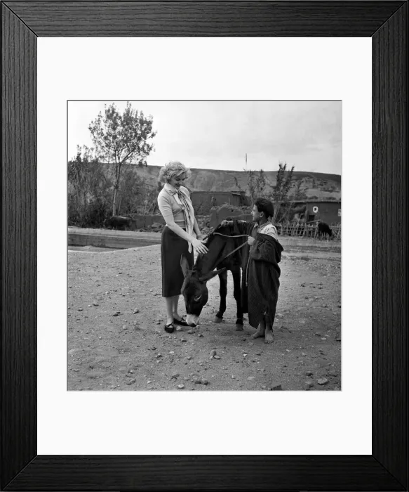Framed Print : A French actress meets a local boy and his donkey in the countryside of Morocco December