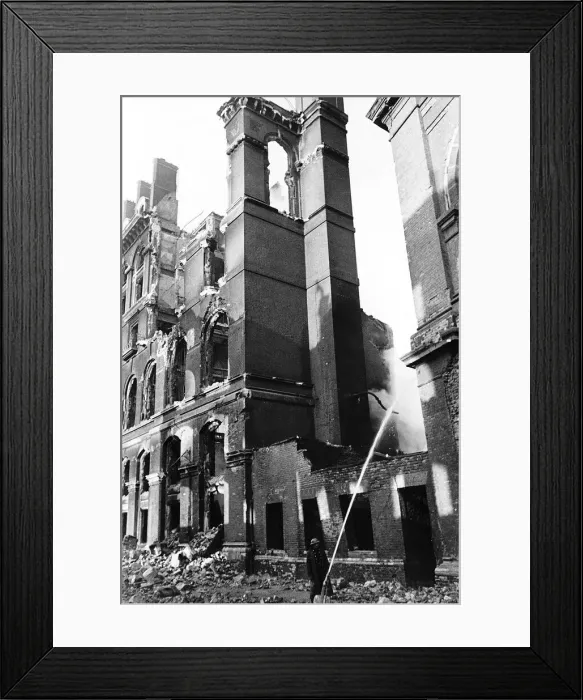 Framed Print : A fireman hoses down smoking remains of a building in Southwark London after an air raid