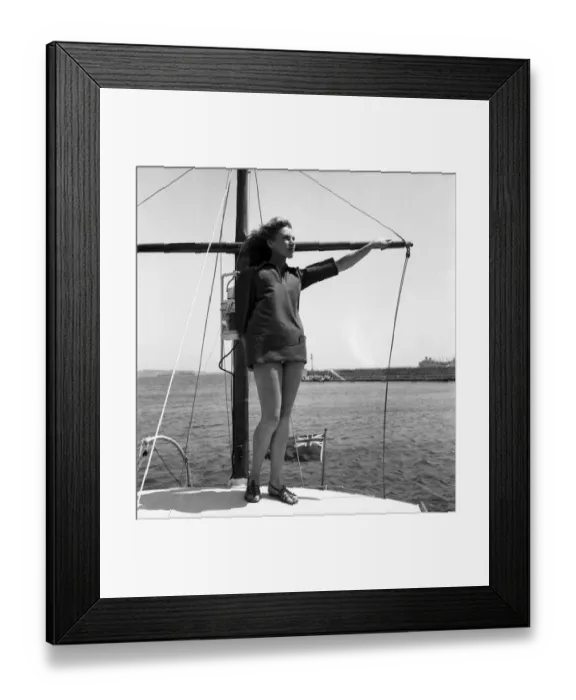 Framed Print : Woman standing on the front of her boat on holiday in South of France. July 1949 O20687