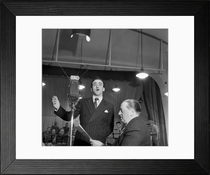 Framed Print : BBC Producer Leslie Bridgemont holds the songsheet for the Singing Waiter as he sings