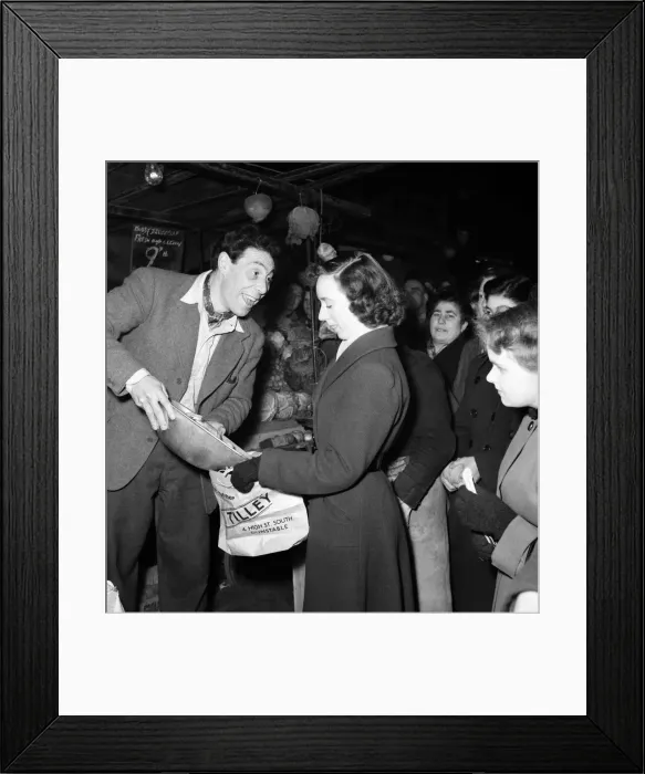 Framed Print : Market trader John Slater sells fruit to a woman on his stall, Chapel Street Market