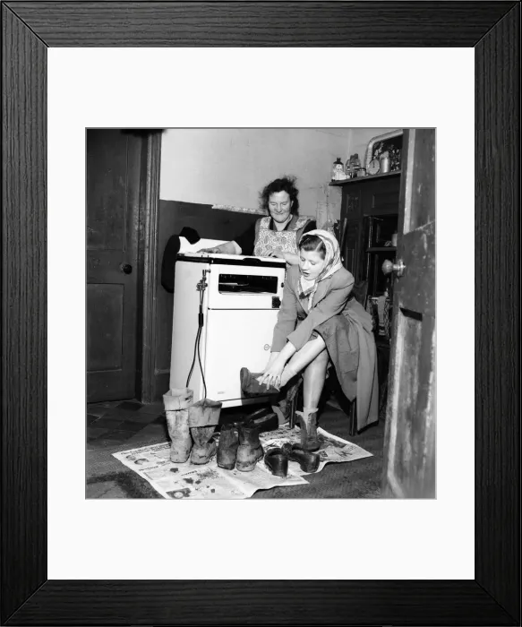 Framed Print : Housewife Mrs. Gladys Coates changes into better footwear after leaving the the mud Framed Print : Housewife Mrs. Gladys Coates changes into better footwear after leaving the the mud