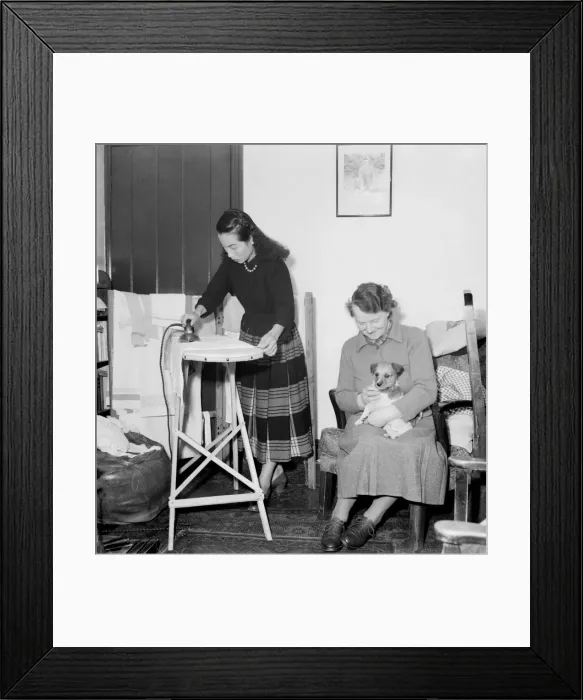 Framed Print : Domestic Scenes A woman ironing in the living room of her home February 1953