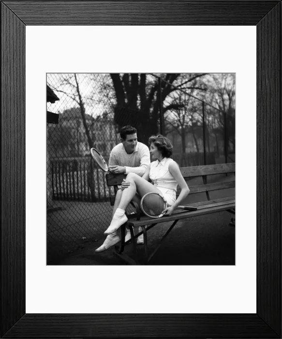 Framed Print : Man and woman talking on a park bench after enjoying a game of tennis January 1953