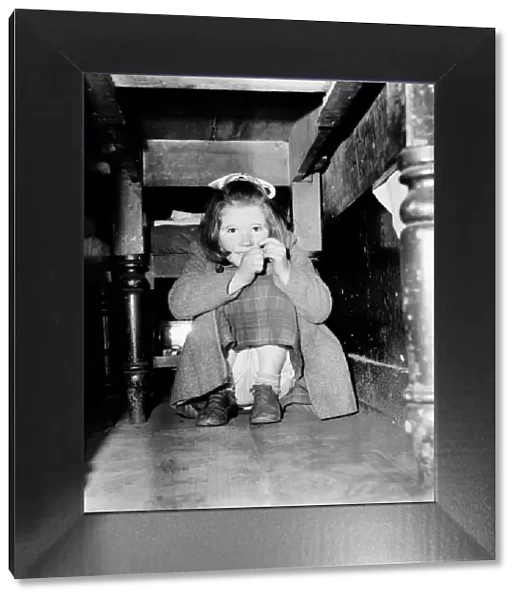 Girl hiding under her table. February 1953 D621