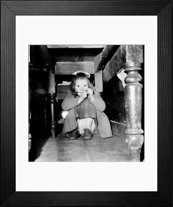 Framed Print : Girl hiding under her table. February 1953 D621
