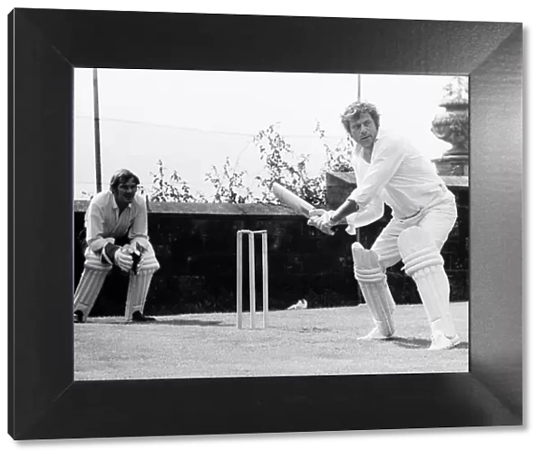Oliver Reed actor at batting practice for a challenge match in the grounds of his home at