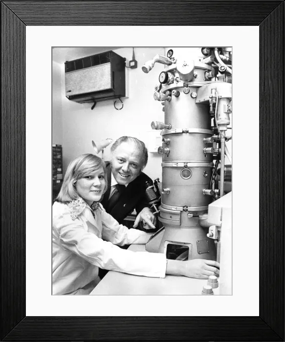 Framed Print : Richard Attenborough looks at an electron microscope with Junior technicain Margaret Mole Framed Print : Richard Attenborough looks at an electron microscope with Junior technicain Margaret Mole