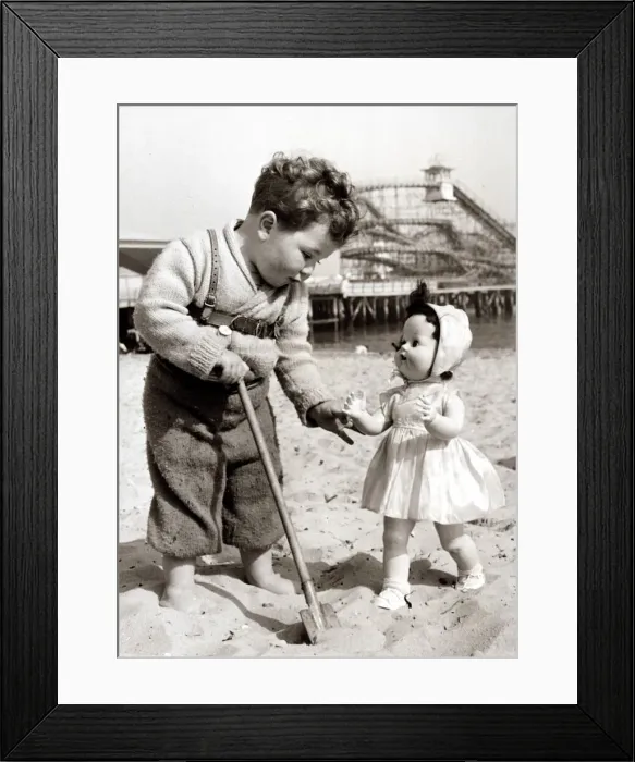 Framed Print : Boy plays with doll on the beach Cute kid on holiday at the seaside Framed Print : Boy plays with doll on the beach Cute kid on holiday at the seaside