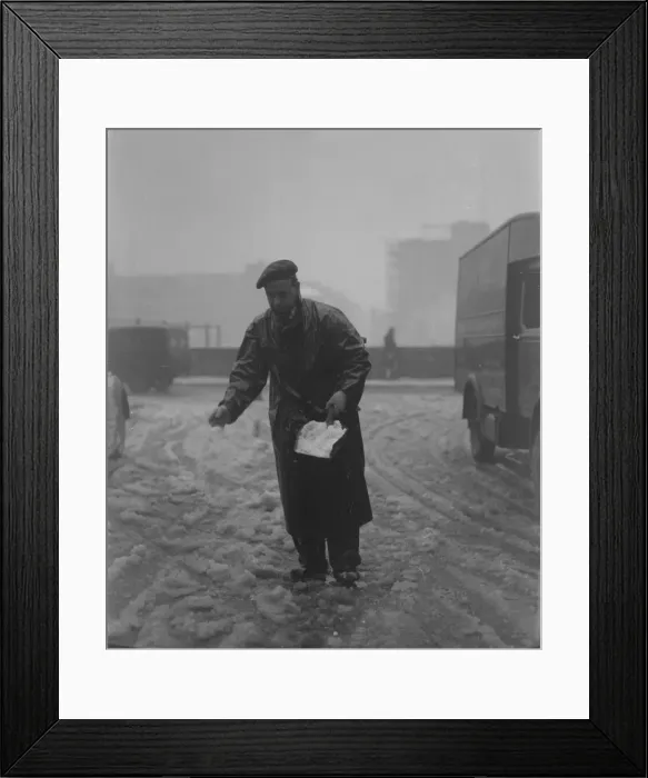 Framed Print : Snow scenes in London - Man springling salt on snow in Fetter Lane DM