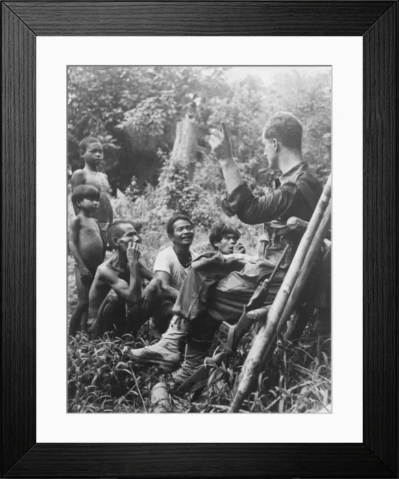 Framed Print : Officer leading British Army patrol stops to chat to tribesmen in Malayan jungle Framed Print : Officer leading British Army patrol stops to chat to tribesmen in Malayan jungle