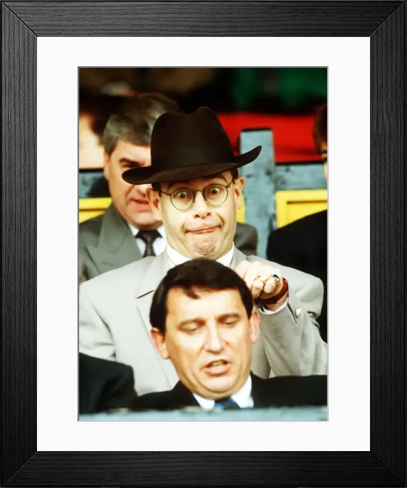 Framed Print : Elton John Singer & Chairman of Watford FC pulls a funny face at Manager Graham Taylor