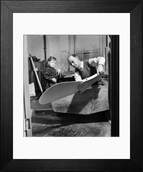 Framed Print : An elderly man in dining room with his grandson building the Royal yacht