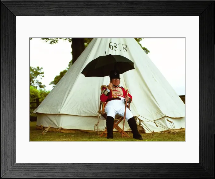 Framed Print : Sgt. Jeff Peacock of the 68th Regiment of Light Infantry shelters from a shower during Framed Print : Sgt. Jeff Peacock of the 68th Regiment of Light Infantry shelters from a shower during