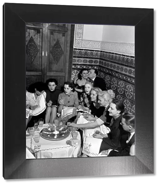 A group of friends gathered around a table enjoying drinks on a night out in Marrakech