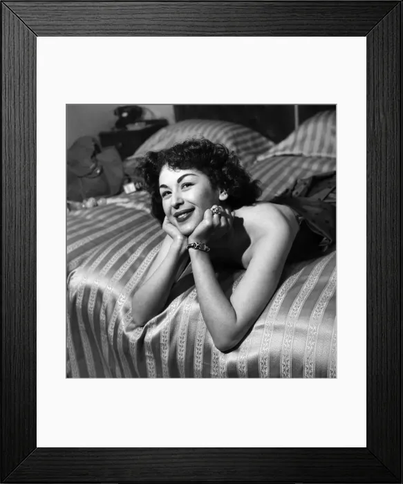 Framed Print : Woman in dress posing on bed. March 1952 C1581-002