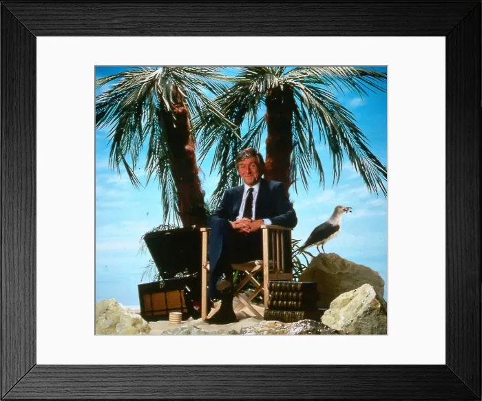 Framed Print : Michael Parkinson TV chat show presenter April 1986 sitting on a chair desert island palm Framed Print : Michael Parkinson TV chat show presenter April 1986 sitting on a chair desert island palm