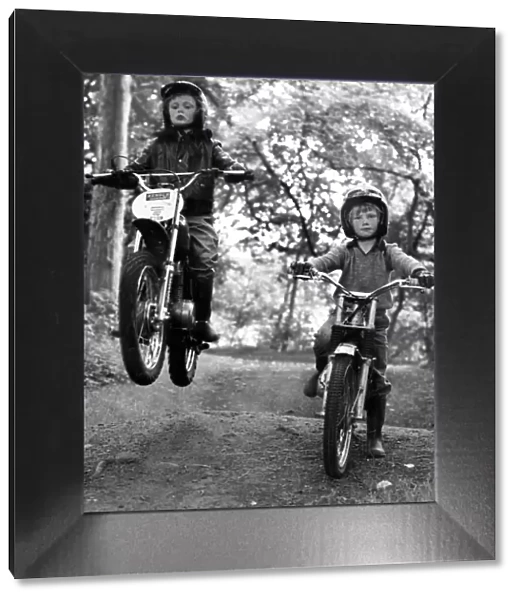 Two young boys Paul and Jason Wilson ride on their motorbikes on a woodland track