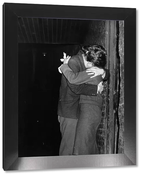 A young couple enjoy a kiss and cuddle