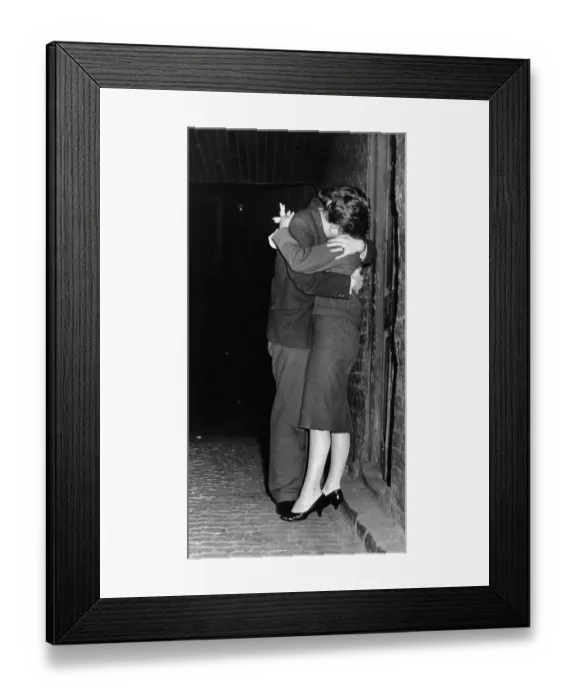 Framed Print : A young couple enjoy a kiss and cuddle Framed Print : A young couple enjoy a kiss and cuddle