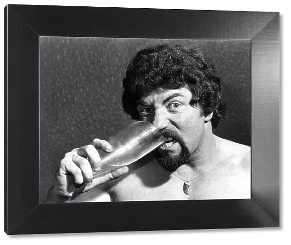 Male Stripper Mel biting a pint glass. June 1977 P018598
