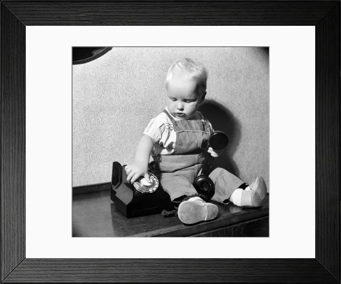 Framed Print : Baby and telephone. August 1952 C4052 Framed Print : Baby and telephone. August 1952 C4052