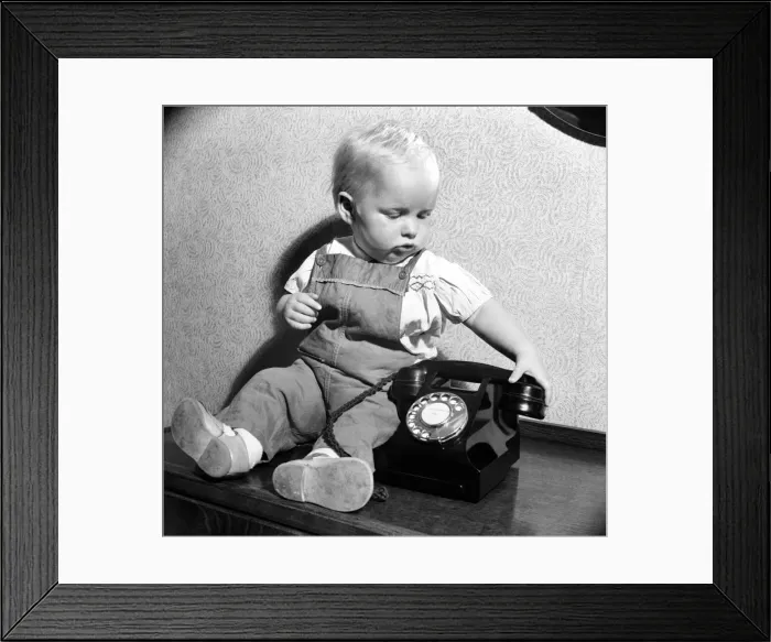 Framed Print : Baby and telephone. August 1952 C4052 Framed Print : Baby and telephone. August 1952 C4052