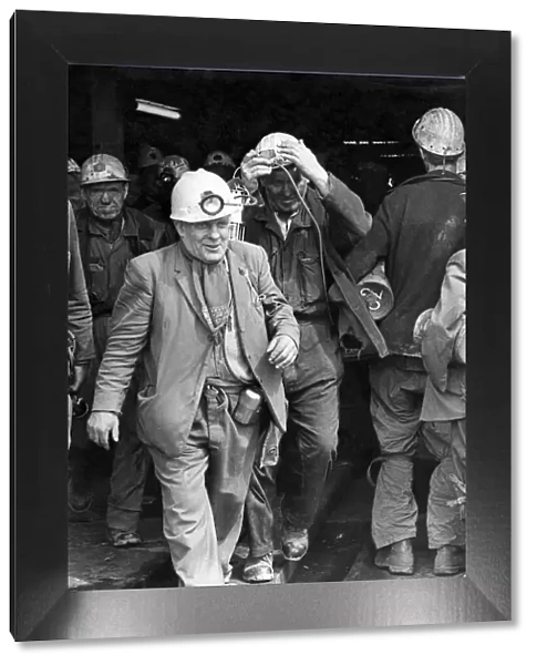 A smiling miner makes his way to the surface cage after his shift