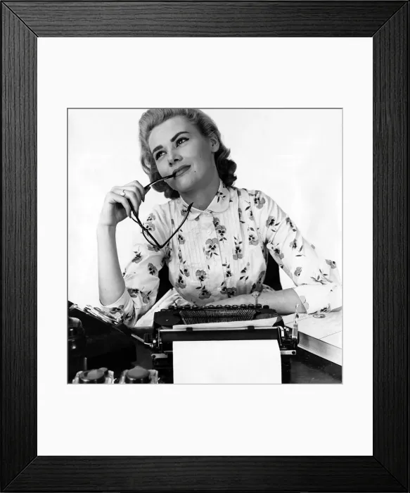 Framed Print : Secretary at typewriter chewing the end of her glasses daydreaming Typist Framed Print : Secretary at typewriter chewing the end of her glasses daydreaming Typist
