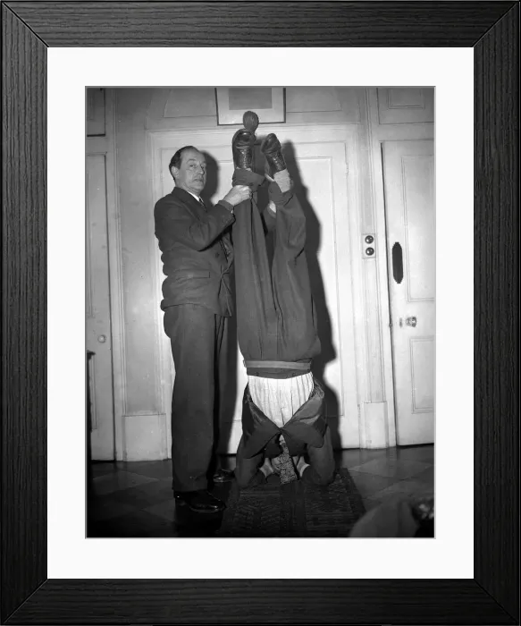 Framed Print : Man does a head stand while other man holds his feet Framed Print : Man does a head stand while other man holds his feet