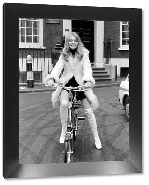 Model Blanche Webb wearing a fur jacket, riding a bicycle. November 1969 Z11350-013