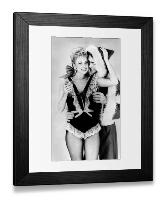 Framed Print : Satin and lace are Santas favourites. Man dressed as Santa with woman wearing Framed Print : Satin and lace are Santas favourites. Man dressed as Santa with woman wearing