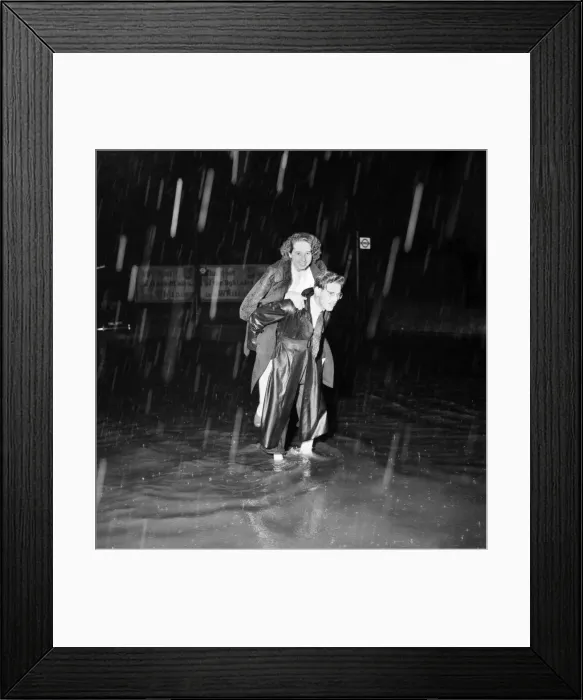Framed Print : A man carries his wife upon his back after heavy rain caused floods in London Framed Print : A man carries his wife upon his back after heavy rain caused floods in London