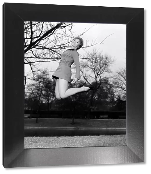 Woman jumping up in the air, smiling wearing mini dress. November 1969 Z11409