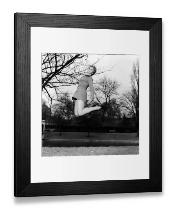 Framed Print : Woman jumping up in the air, smiling wearing mini dress. November 1969 Z11409