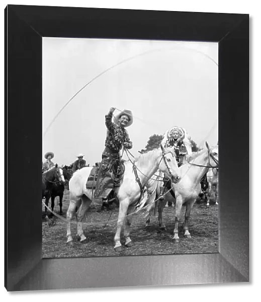 Cal McAndrew on horseback with a lasso seen alongisde - Carol Gray dressed as a Indian