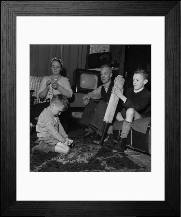 Framed Print : Family Life in Oldham 1952. Mother sews while father watch his youngest son play Framed Print : Family Life in Oldham 1952. Mother sews while father watch his youngest son play