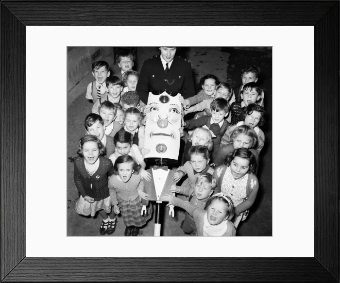 Framed Print : Children: Road safety a set of talking traffic lights teaches road safety to these infant