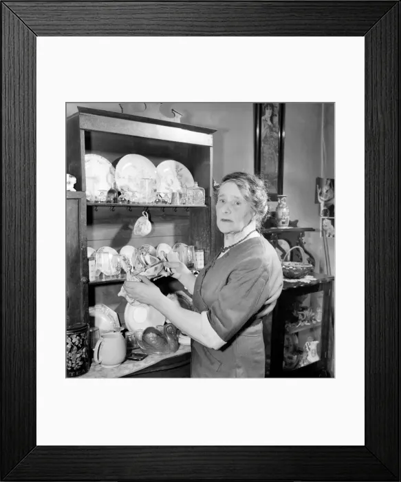 Framed Print : House wife arranging nik-naks on Welsh dresser. D5038