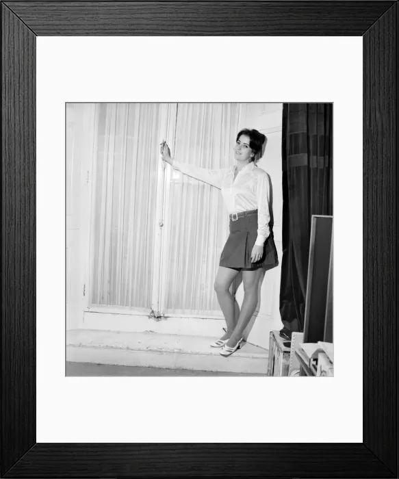 Framed Print : Woman poses wearing a white blouse with black skirt. November 1969 Z10585