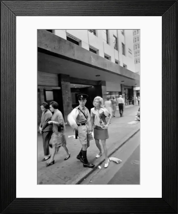 Framed Print : Woman on a visit to Hong Kong for a shopping trip asks a policeman for directions Framed Print : Woman on a visit to Hong Kong for a shopping trip asks a policeman for directions