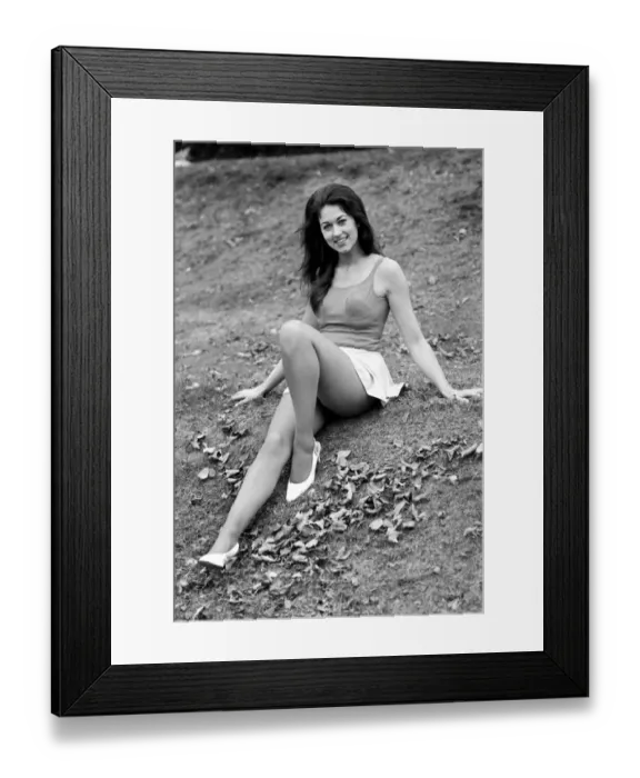 Framed Print : Woman posing outdoors wearing a short white skirt and vest top