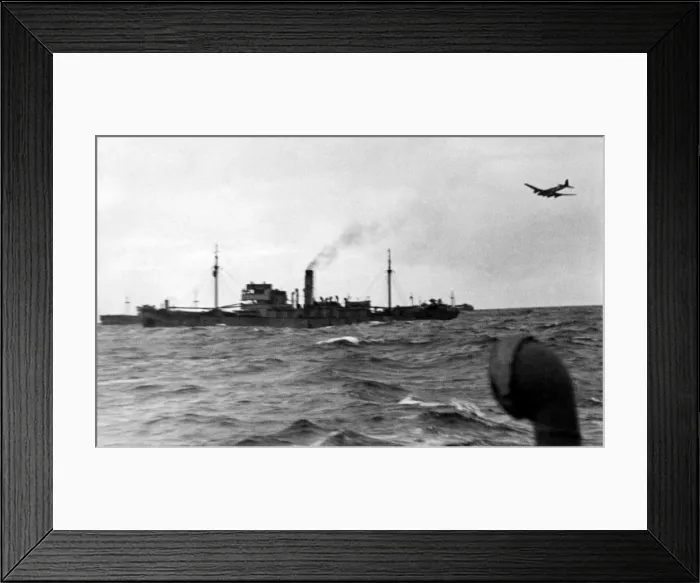 Framed Print : A Nazi bomber sweeps out of the clouds to attack a convoy in the mid Atlantic