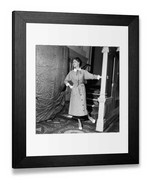 Framed Print : Linda Leigh Fashion Show. Woman poses by the stairs wearing a long check patterned dress