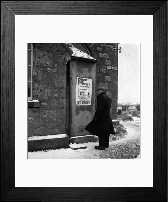 Framed Print : An elderly man reading a notice put up on the wall of his local church in Scalloway Framed Print : An elderly man reading a notice put up on the wall of his local church in Scalloway